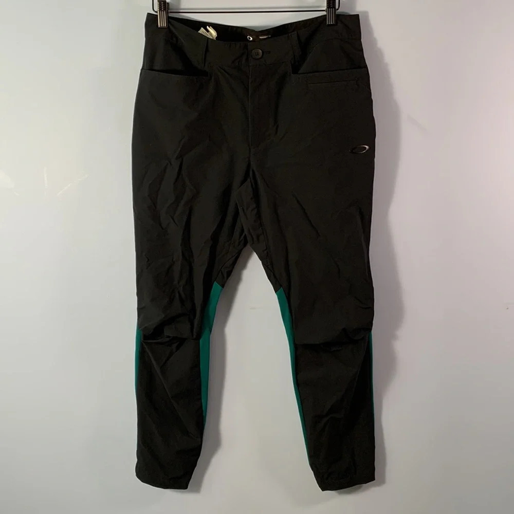 Oakley’s mens size 32 performance fit black athletic pants teal contrast back